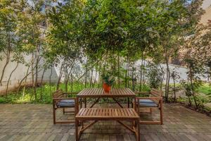 a picnic table and two benches with a plant on it at Hermitage Road Apartment By Morethanstays in London