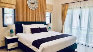 a bedroom with a large bed and windows at Malinee Villa Phuket in Bang Tao Beach +73 photos