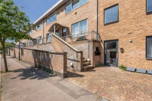 a brick building with a staircase in front of it at Hermitage Road Apartment By Morethanstays in London