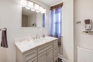 a white bathroom with a sink and a mirror at Close to Dtwn Bangor Inviting Maine Home in Veazie +18 photos