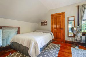 a bedroom with a bed and a fan and a window at 3 Mi to Road America Spacious Elkhart Lake Home! in Elkhart Lake
