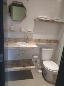 a bathroom with a toilet and a sink and a mirror at 004 Suite - Banheira de imersão - PRAIA -Temp Ambiente in João Pessoa +2 photos
