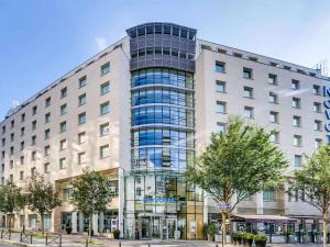 a tall white building with a lot of windows at Novotel Paris Centre Gare Montparnasse in Paris
