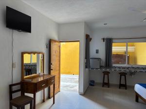a room with a bedroom with a desk and a bed at Hotel Rodríguez in Izamal