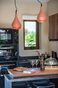 a kitchen with a counter with two glasses of wine at Nestor Luxury Villas in Romanu