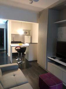 a living room with a couch and a table and a kitchen at Rua Dr Diogo de Faria 671 Apto 13 in Sao Paulo