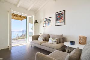 un salon avec un canapé et une table dans l'établissement "Pini House", inside a Private Park, shared Pool, Tennis, AC, Parking next home and Parking in Lerici!, à Lerici