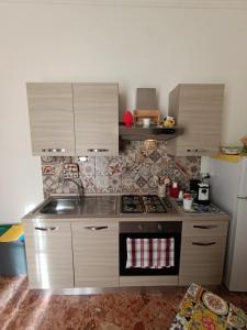 a small kitchen with a stove and a refrigerator at Arco del vescovo 2 in Acireale