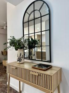 a mirror on a wooden table with two vases at La Roca in Losa del Obispo