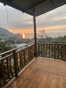a wooden deck with the sunset in the background at La casa abue in San Pablo La Laguna
