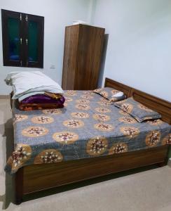 a bed with a blue comforter and pillows on it at Nature valley home stay in Marchula