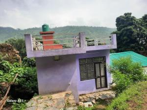 a small house with a balcony on top of it at Nature valley home stay in Marchula