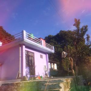 a small house with a balcony on top of it at Nature valley home stay in Marchula