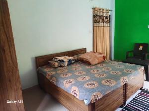 a bed in a room with a green wall at Nature valley home stay in Marchula +17 photos