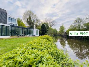 a building with a sign next to a river at Villa EMG Warendorf Münster - Warendorf in Warendorf