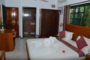 een slaapkamer met een bed met handdoeken erop bij Pension Michel in La Digue