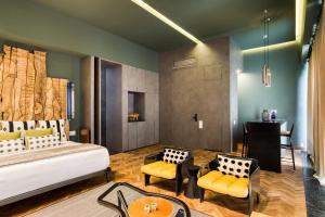 a bedroom with a bed and two yellow chairs at El Alfonsa in Mexico City +165 photos
