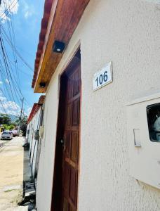 a door to a house with a sign on it at Microcasa Aconchego Paraty in Paraty