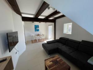 a living room with a black couch and a table at Pauerhof Ferienwohnungen in Bad Nenndorf