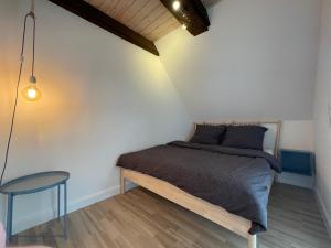 a small bedroom with a bed and a stool at Pauerhof Ferienwohnungen in Bad Nenndorf