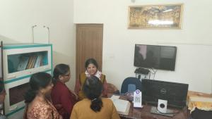 eine Gruppe von Frauen, die in einem Raum an einem Tisch sitzen in der Unterkunft Rajlaxmi Resort - Pure Veg in Bolpur