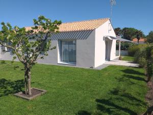a small tree in a yard next to a house at Maison neuve en Vendée, 3 chambres, proche véloroute et océan, wifi, terrasses, tout inclus. - FR-1-426-542 in Beauvoir-sur-Mer