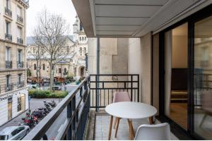 a balcony with a table and chairs and a street at Appartement champ elysee in Neuilly-sur-Seine
