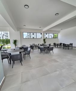 a large room with tables and chairs and windows at Apto. El Escape Punta Cana, impuestos incluidos in Punta Cana