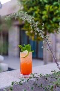 a drink with a green garnishment sitting on a table at Nestor Luxury Villas in Romanu