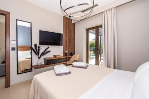 a bedroom with a white bed and a large mirror at Nestor Luxury Villas in Romanu