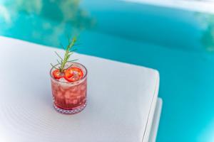 a drink with a tomato on top of a table at Nestor Luxury Villas in Romanu
