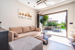 a living room with a couch and a table at Nestor Luxury Villas in Romanu