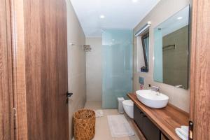 a bathroom with a sink and a toilet and a mirror at Nestor Luxury Villas in Romanu