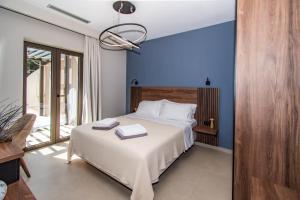 a bedroom with a bed with a blue wall at Nestor Luxury Villas in Romanu