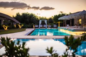 a pool with a gazebo in a backyard at Nestor Luxury Villas in Romanu