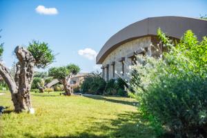 a building in a park with a green yard at Nestor Luxury Villas in Romanu