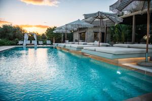 a swimming pool with couches and an outdoor gym at Nestor Luxury Villas in Romanu