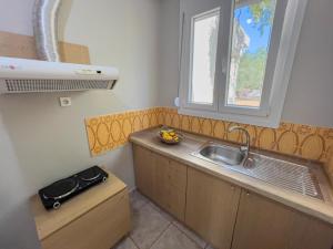 a small kitchen with a sink and a window at Sivi's Vacation Homes in Skala Kallirachis +49 photos