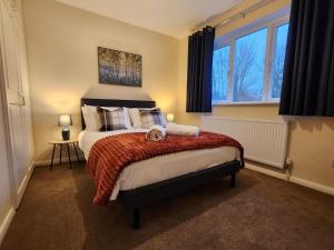 a bedroom with a large bed and a window at Bicester villa, 5Bedroom, Parking, WiFi, Garden in Bicester