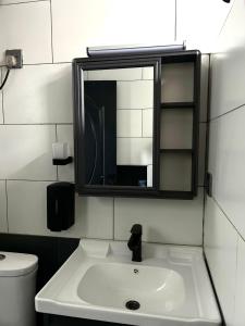 a bathroom with a white sink and a mirror at CosyNook B in Kigali +21 photos