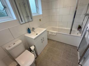 a bathroom with a toilet and a sink and a tub at Bicester villa, 5Bedroom, Parking, WiFi, Garden in Bicester +21 photos