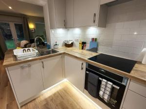a kitchen with white cabinets and a sink at Bicester villa, 5Bedroom, Parking, WiFi, Garden in Bicester