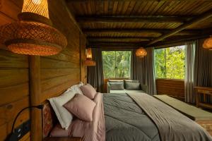 ein Schlafzimmer mit einem Bett in einer Blockhütte in der Unterkunft Grajagan Mata Atlântica in Antonina