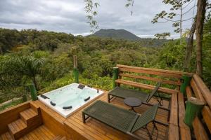 einen Whirlpool auf einer Holzterrasse mit 2 Stühlen in der Unterkunft Grajagan Mata Atlântica in Antonina