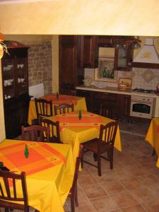 a kitchen with two tables with yellow and orange covers at Masseria Rosella - Longhi in Pietrelcina