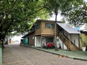 a house with a motorcycle parked in front of it at Pousada Quintal Verde Floripa in Florianópolis