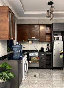 a kitchen with stainless steel appliances and wooden cabinets at CosyNook B in Kigali