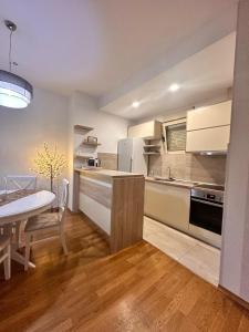 a kitchen with white appliances and a table in a room at Posto Capitano apartment Sasa in Kotor
