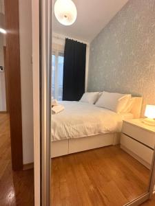 a bedroom with a bed with a window and a mirror at Posto Capitano apartment Sasa in Kotor +9 photos