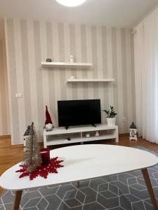 a living room with a tv and a white table at Posto Capitano apartment Sasa in Kotor